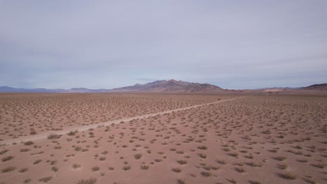 small-narrowed-off-road-pass-trough-Nevada-desert-in-usa-scenic-desert-arid-aerial-landscape