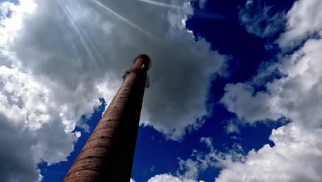Timelapse-of-a-chimney-or-high-tower-with-blue-sky-with-white-clouds-background