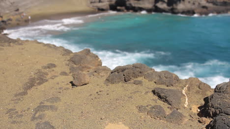 Waves-Crash-Against-Shore-behind-Black-Rocks-on-Green-Sand-Beach-in-Hawaii