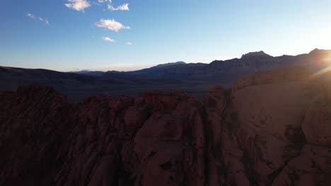 Drohne-Fliegt-In-Der-Nähe-Einer-Roten-Felsformation,-Die-Einen-Malerischen-Sonnenuntergang-Hinter-Der-Riesigen-Felsschlucht-In-Kalifornien-Las-Vegas-Usa-Enthüllt