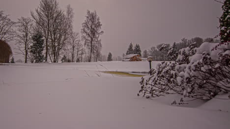 Statische-Aufnahme-Von-Hütten-Neben-Einem-Zugefrorenen-See-Mit-Schneefall-An-Einem-Kalten,-Windigen-Wintertag