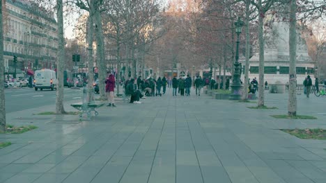 People-walking-on-the-Place-de-la-Bastille-in-the-Parisian-capital,-European-winter-season,-high-traffic-and-congestion