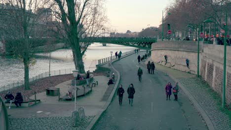 People-spending-time-outdoors-on-the-banks-of-the-Seine-River,-Ile-de-France,-Paris