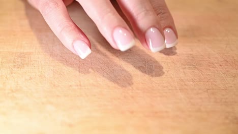 perfectly-manicured-finger-nails-tapping-on-wood