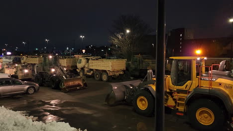 Pan-view-of-parking-lot-of-trucks-to-remove-snow