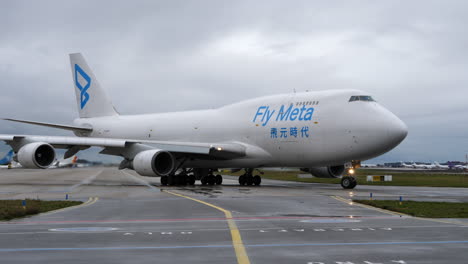 Fly-Meta-Cargo-Jumbo-B747-Avión-Rodando-En-El-Aeropuerto,-Día-Nublado
