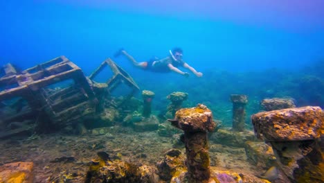 Man-snorkeling-close-to-submerged-garbage-like-structure-in-the-sea