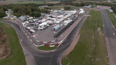 Wide-aerial-orbiting-shot-showing-racecars-at-racetrack-in-Sweden