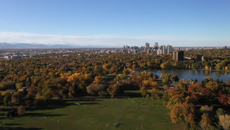 Aerial-drone-shot-flying-over-beautiful-Denver-park-in-the-fall-with-city-skyline-in-the-background