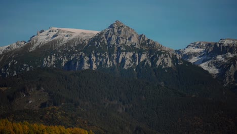 Panoramic-shot-of-a-tall-snowy-mountain-ridge,-clear-sunny-warm-day