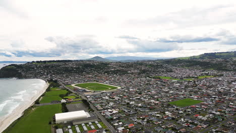 Aerial-drone-view-of-Dunedin-coastal-city-from-above-in-New-Zealand-in-cloudy-day