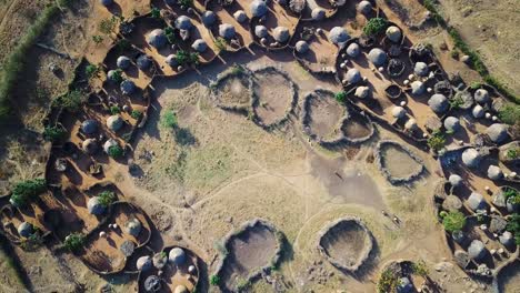 Aerial-drone-zoom-out-view-from-the-center-of-a-village-in-the-Karamoja-region,-also-called-Manyatta-or-Ere,-in-Uganda,-during-a-sunny-day
