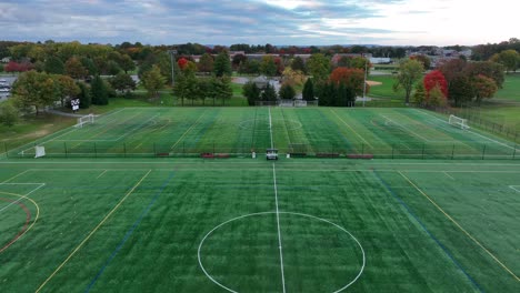 Aerial-view-of-two-turf-fields-on-school-property-for-field-hockey,-lacrosse,-football,-soccer,-and-more-extracurricular-sport-activities