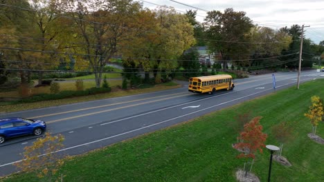 Aerial-view-of-school-bus-driving-on-main-road