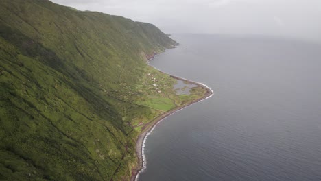 Dramatic-wide-aerial-view-of-Fajã-dos-Cubres-at-foot-of-collapsed-sea-cliff