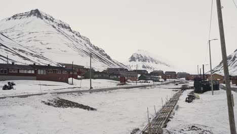 Iconic-village-and-snowy-mountains-of-Svalbard,-handheld-view