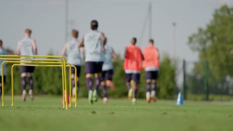 Static-slow-motion-shot-of-out-of-focus-soccer-players-jogging
