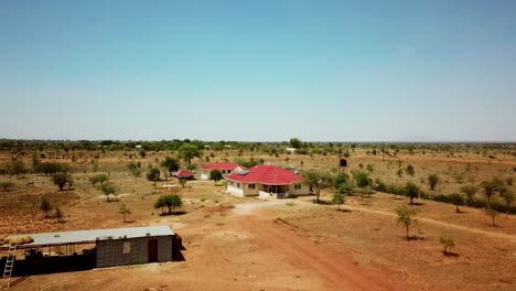 Luftaufnahme,-Die-An-Einem-Sonnigen-Tag-In-Uganda,-Afrika,-Von-Einem-Karamoja-Dorfhaus-Wegzoomt