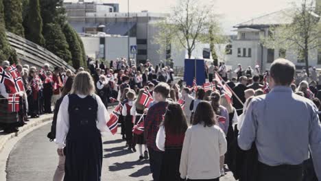 Kids-waving-Norway-flag-during-Institution-day-in-Molde-city,-handheld-slow-motion