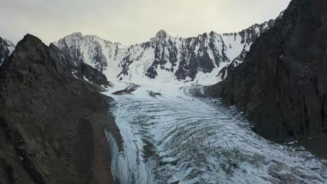 Rotating-revealing-drone-shot-of-an-opening-in-the-Ak-Sai-glacier-in-Kyrgyzstan