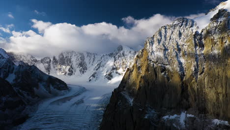 Toma-Aérea-Cinematográfica-épica-De-Un-Gran-Pasaje-Y-Una-Montaña-En-La-Cima-Del-Glaciar-Ak-sai-Durante-La-Puesta-De-Sol-En-Kirguistán