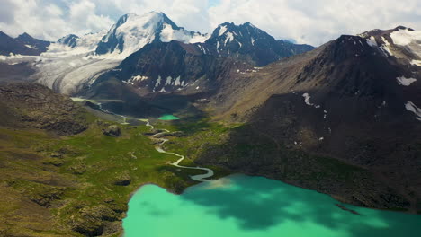 Aerial-drone-shot-of-a-mountain-range-looking-down-on-the-Ala-Kol-lake-in-Kyrgyzstan
