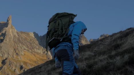 Slow-motion-tracking-shot-of-man-with-backpack-hiking-in-mountains-of-Norway