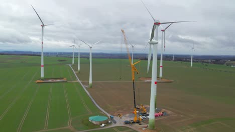 A-Symbol-of-Renewable-Energy:-A-Crane-Assists-in-the-Construction-of-a-Wind-Turbine-on-a-overcast-day-in-Bad-Wünnenberg,-Paderborn,North-Rhine-Westphalia,-Germany