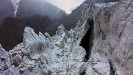 Cinematic-aerial-drone-shot-going-through-a-gap-in-the-Ak-Sai-glacier-in-Kyrgyzstan