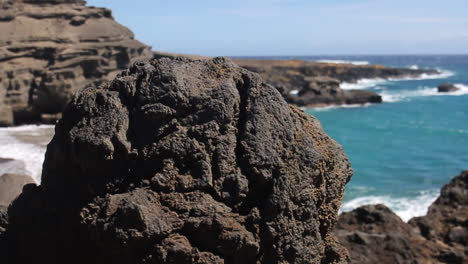Wellen-Krachen-Gegen-Die-Küste-Hinter-Schwarzen-Felsen-Am-Grünen-Sandstrand-In-Hawaii