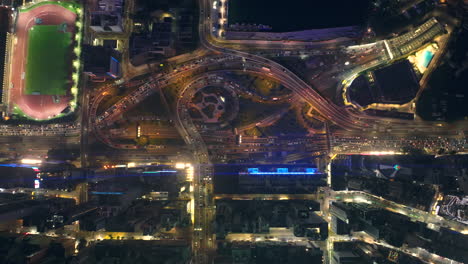 Aerial-top-down-flight-over-busy-road-and-traffic-in-Causeway-Bay,-Hong-Kong-at-night
