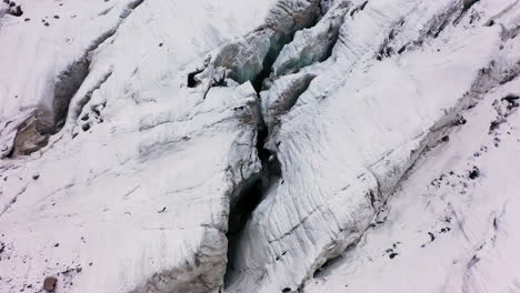 Cinematic-revealing-drone-shot-of-a-large-crevasse-in-the-Ak-Sai-glacier-in-Kyrgyzstan