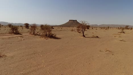 Riding-through-the-Sahara-Desert-sands-in-Morocco-towards-a-butte
