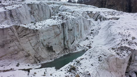 Rotating-revealing-drone-shot-of-a-large-opening-and-ravine-in-the-Ak-Sai-glacier-in-Kyrgyzstan