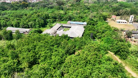 Aerial---Forward-tilt-down-shot-of-secluded-school-compound-in-sub-Saharan-Africa