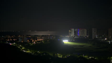 Aerial-view-of-the-golf-range-in-Puerto-Cancun-at-night-with-the-caribbean-sea-behind-and-isla-mujeres