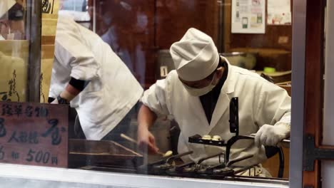 Vendedor-De-Comida-Callejera-Preparando-Deliciosos-Bocadillos,-Asakusa,-Tokio,-Japón
