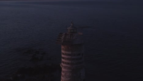 Static-cinematic-establisher-shot-of-flashing-offshore-Lighthouse-at-dusk