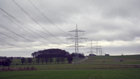 Bringing-Power-to-the-People:-Timelapse-of-Electrical-Transmission-Lines-in-a-Cloudy-Sky-over-Green-Fields