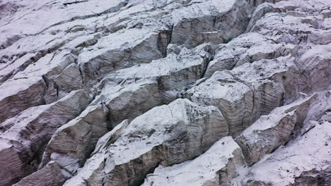 Rotierende-Filmische-Drohnenaufnahme-Des-Schneebedeckten-Und-Felsigen-Geländes-Des-Ak-Sai-Gletschers-In-Kirgisistan