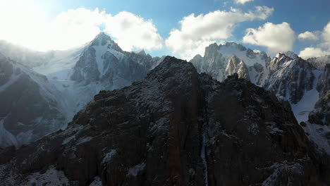 Girando-Un-Dron-Cinematográfico-épico-De-La-Cima-De-Una-Montaña-Rodeada-De-Montañas-Más-Altas-En-El-Glaciar-Ak-sai-En-Kirguistán