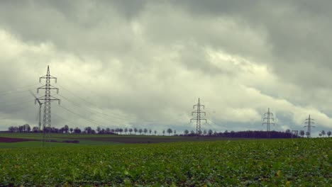 Bringing-Energy-to-Life:-Timelapse-of-Electrical-Transmission-Lines-in-a-Cloudy-Sky-over-Green-Fields