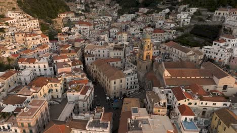 Amalfi,-Italien-Bei-Sonnenaufgang-Mit-Drohnenvideo-Der-Skyline,-Die-Sich-Von-Der-Kirche-Zurückzieht-Und-Nach-Oben-Neigt
