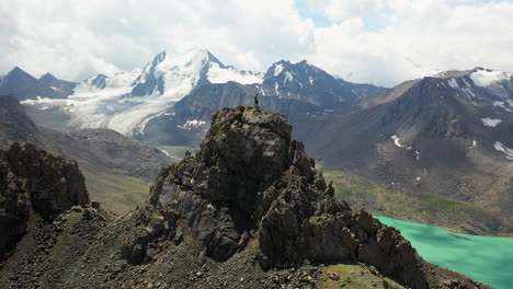 Mann-Steht-Auf-Einer-Bergkette-Mit-Blick-Auf-Den-Ala-kol-see,-Kirgisistan,-Schöne-Aussicht,-Große-Leistung,-Umkreisende-Drohne