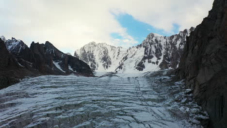 Cinematic-aerial-drone-shot-going-up-the-side-of-the-Ak-Sai-glacier-in-Kyrgyzstan
