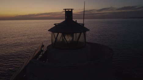 Nahaufnahme-Eines-Markanten-Einsamen-Leuchtturms,-Der-Die-Meereslandschaft-In-Der-Abenddämmerung-Beleuchtet