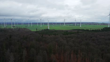 Sustainable-Energy-Production-in-North-Rhine-Westphalia:-Row-of-Wind-Turbines-at-Wind-Farm-near-Bad-Wünnenberg,-Paderborn-Surrounded-by-Trees