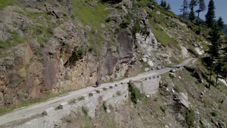 The-solo-motorbike-rider,-professional-touring-motorcyclist-on-a-stunning-mountain-road-in-Kashmir-mountains
