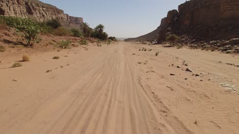 Riding-along-an-off-road-trail-in-Morocco's-Sahara-Desert---motorcycle-rider-point-of-view