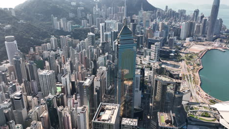 Aerial-orbiting-shot-on-a-bright-day-of-Wan-Cha-district-and-prominent-Central-Plaza-skyscraper-in-foreground-and-Central-financial-district-in-background